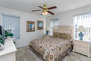 A bedroom with a bed, nightstands, a ceiling fan, and framed pictures on the wall. - Legacy Park 212 (Davenport)