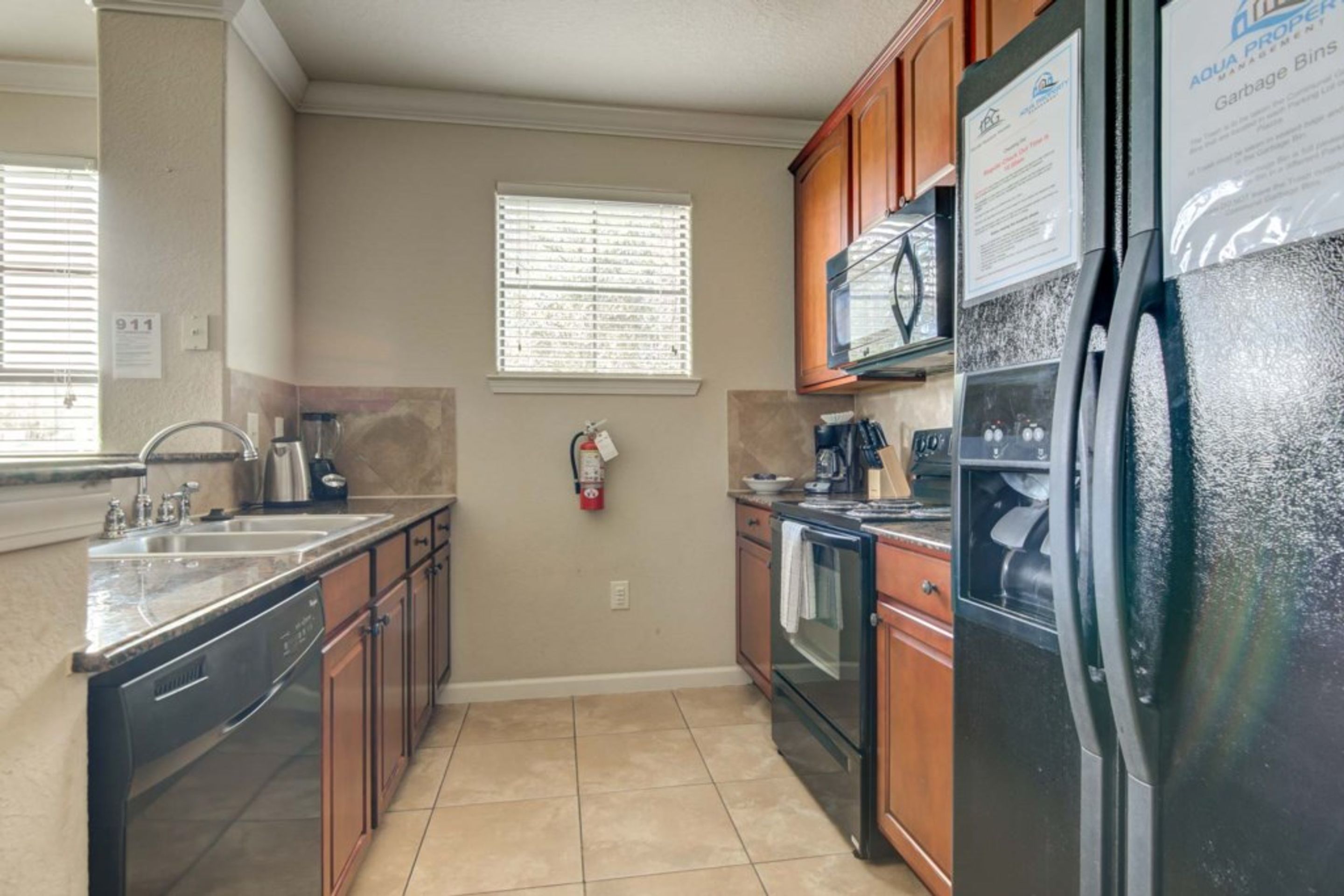 A kitchen with a sink, stove, oven, and refrigerator.