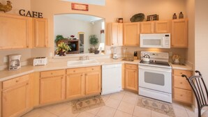 A kitchen with wooden cabinets, a microwave, a stove, and a dishwasher. - The Hamlet at Westhaven 238 (Davenport)