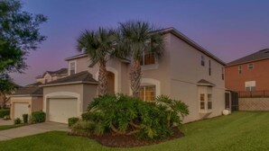 A two-story house with a garage, palm trees, and a well-maintained lawn. - Emerald Island Resort 2801 (Kissimmee)