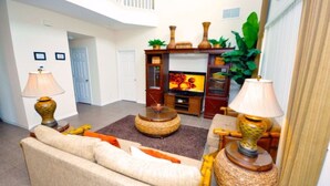 A living room with a sofa, two lamps, a TV, and a coffee table. - Emerald Island Resort 2801 (Kissimmee)