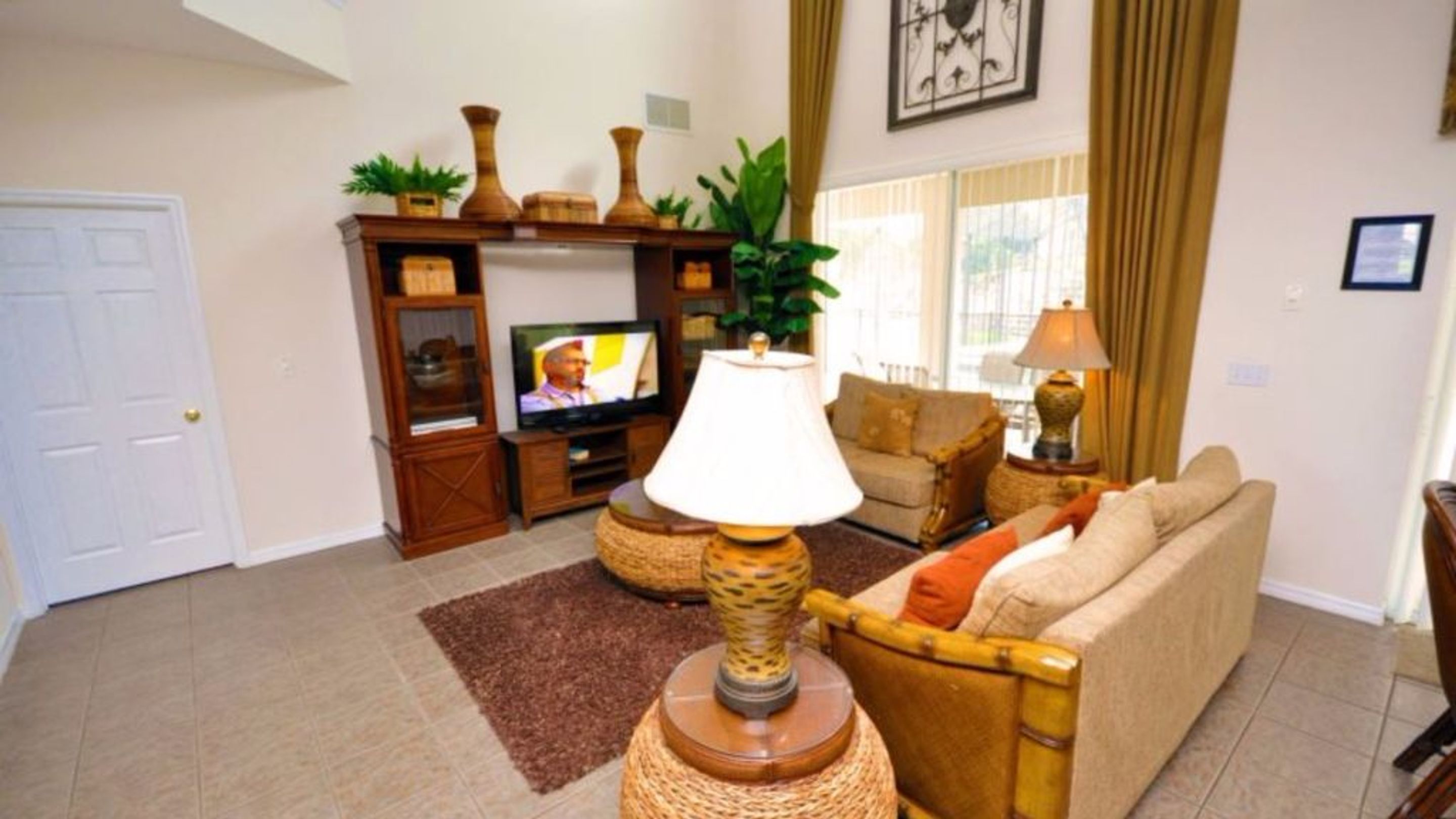 A living room with a television, a lamp, a sofa, and a coffee table.