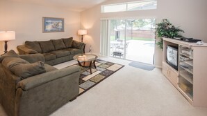 A living room with a sofa, a coffee table, and a cabinet. - Westridge 110 (Davenport)