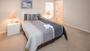 A bedroom with a bed, nightstands, a window, and a door. - Westridge 110 (Davenport)