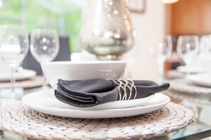 A table set with a folded napkin, a white plate, and a glass. - Crystal Cove 919 (Kissimmee)