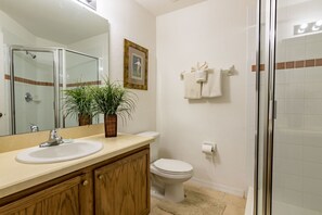 A bathroom with a sink, toilet, and shower.