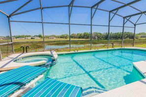 A clear pool with a hot tub, surrounded by a covered area with lounge chairs. - Marbella 1020 (Davenport)