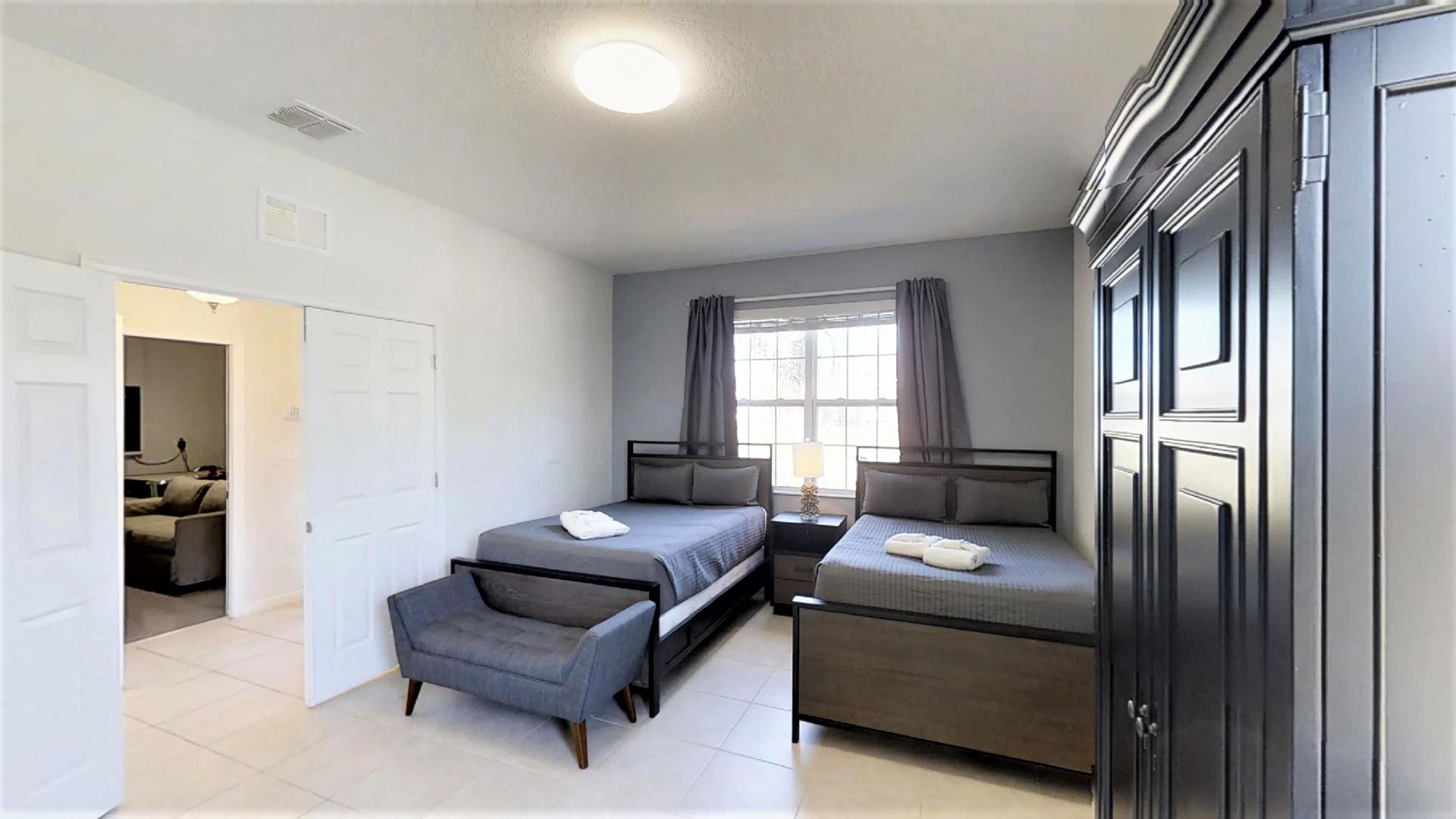 Une chambre moderne avec deux lits, un canapé et un meuble.