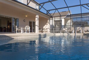 Piscina com teto de vidro, área de estar externa e vista do céu.
