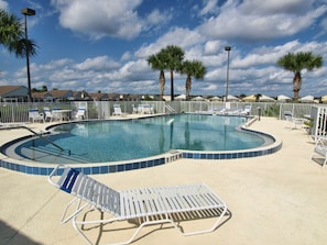 A swimming pool with lounge chairs and palm trees. - Hampton Lakes 863 (Davenport)