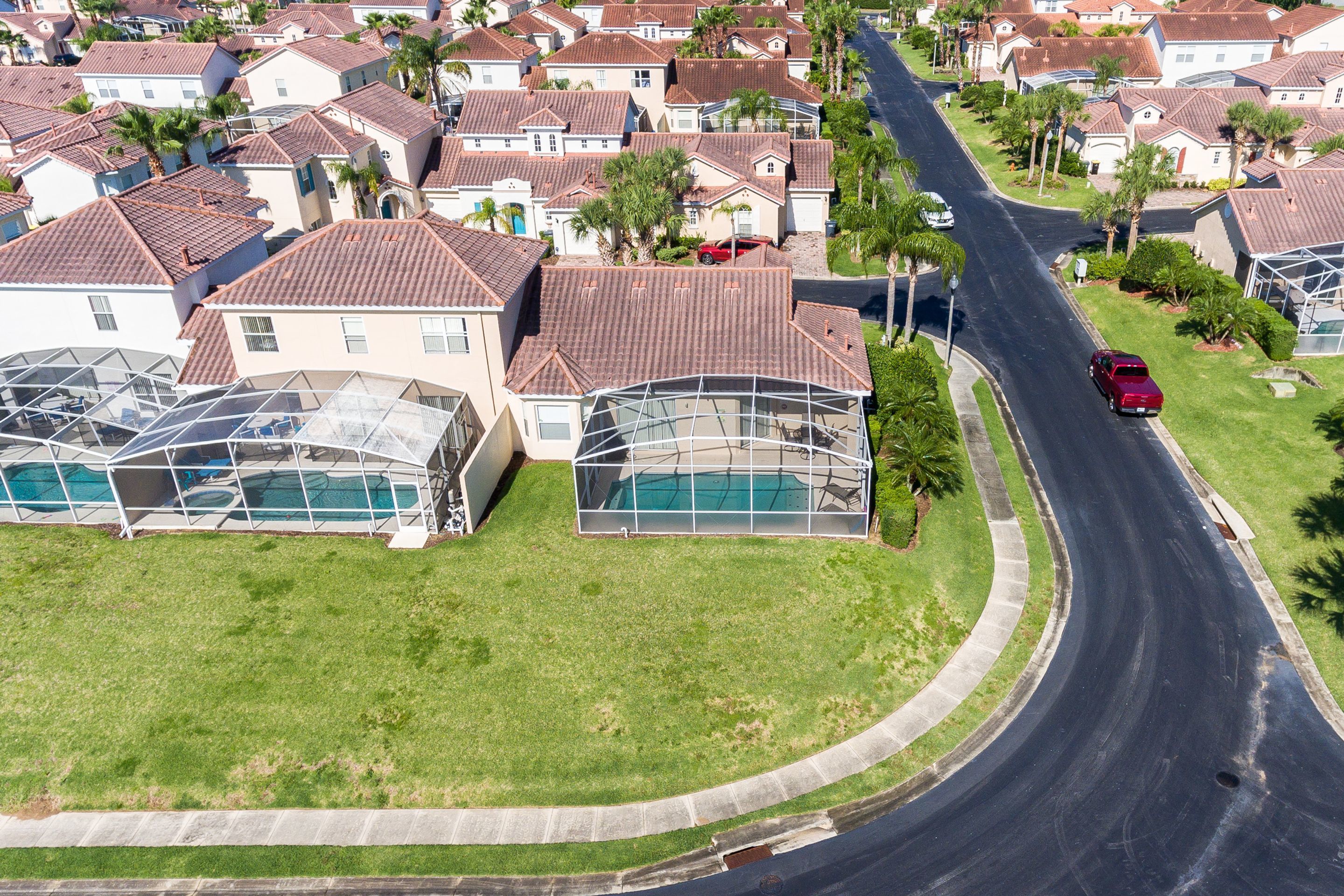 Un quartiere residenziale con case, una strada curva e una piscina.
