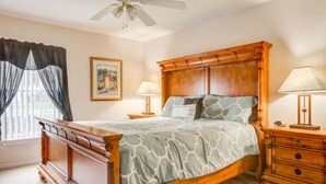 A bedroom with a wooden bed, two bedside tables, a ceiling fan, and a window with curtains. - Silver Creek 17317 (Clermont)