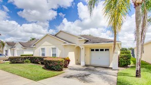 A residential neighborhood with single-family homes, a well-maintained lawn, and a palm tree. - Silver Creek 17317 (Clermont)