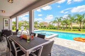 A covered patio with a pool, outdoor furniture, and a clear view of the surrounding neighborhood. - Encore Resort at Reunion 7736 (Kissimmee)