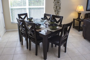 Enjoy meals with friends and family at this dining area, featuring a round table and comfortable seating for six.