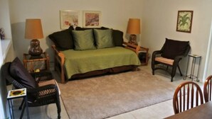 Une chambre à coucher comprenant un lit, deux tables de chevet, une chaise, une table et une lampe.