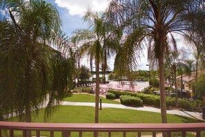 A resort with a pool area, palm trees, and a well-maintained lawn. - Vista Cay 4862 - 202 (Orlando)