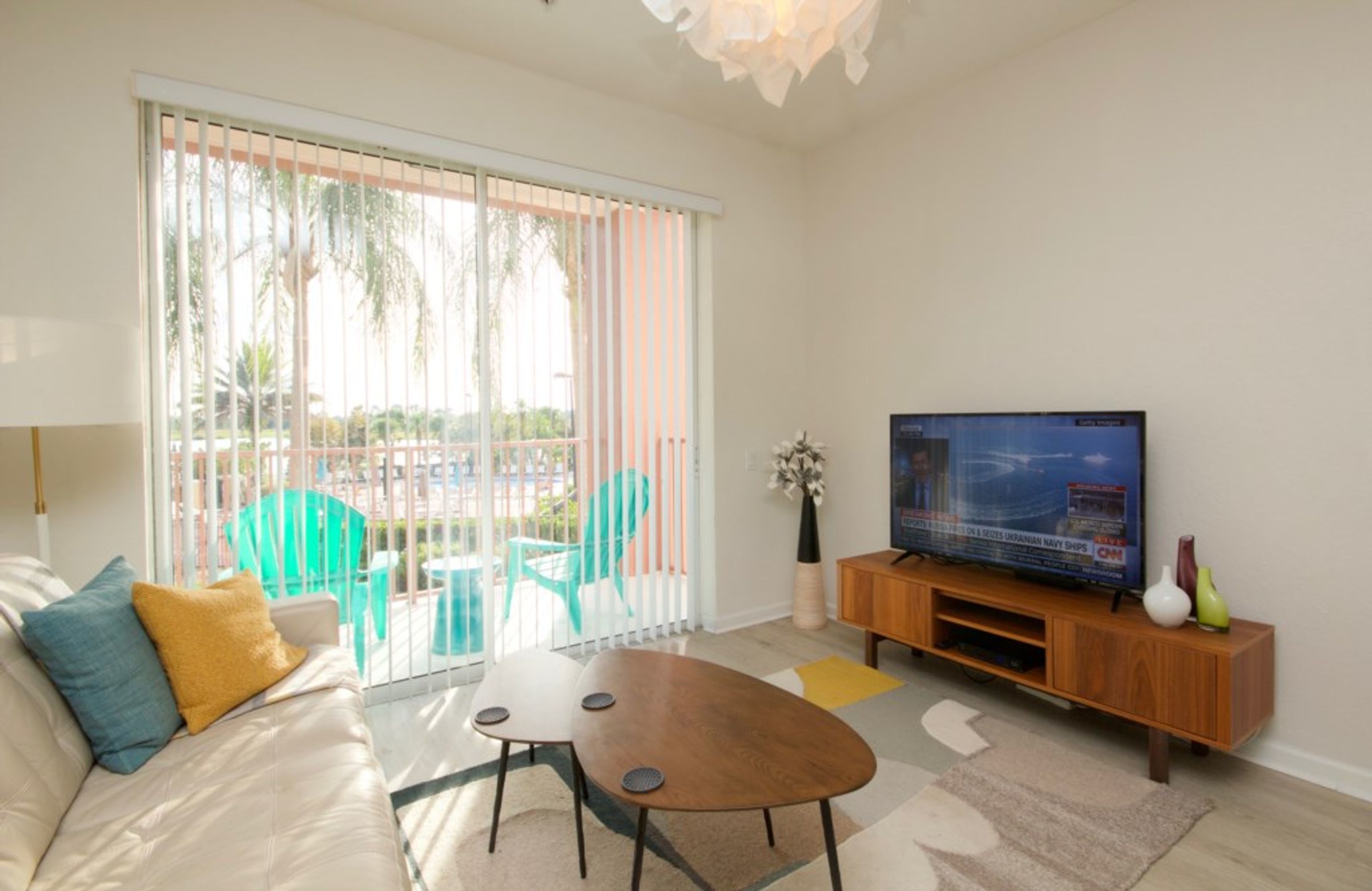 A modern living room with a sofa, coffee table, and TV on a wooden stand.