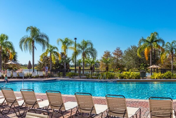 A swimming pool with lounge chairs and palm trees in the background. - Vista Cay 4862 - 202 (Orlando)