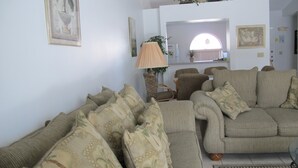 A living room with multiple sofas and armchairs, a lamp, and framed artwork on the walls. - Indian Wells 5356 (Kissimmee)