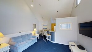 A compact living space with a sofa, a small dining area, and a kitchenette.