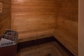 A sauna with wooden walls and a metal bench.