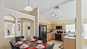 A modern kitchen with a built-in island, stainless steel appliances, and wooden cabinets. - Rolling Hills 7979 (Kissimmee)