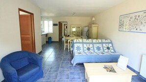 Een kamer met een bed, een stoel, een tafel en een kaart aan de muur.
