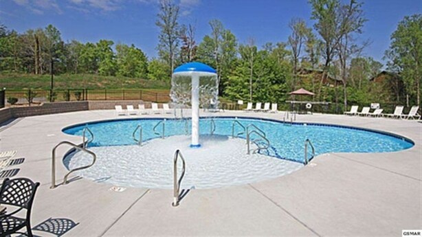 A swimming pool with a water fountain, lounge chairs, and a gazebo. - Updated Clean Spacious 3BR/2BA Condo right off the parkway! Pools/WiFi/Grills (Pigeon Forge)