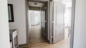 A hallway with a wooden floor, white walls, and a door leading to another room. - Updated Clean Spacious 3BR/2BA Condo right off the parkway! Pools/WiFi/Grills (Pigeon Forge)