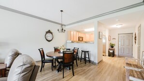 A dining area with a round table, chairs, and a chandelier. - Updated Clean Spacious 3BR/2BA Condo right off the parkway! Pools/WiFi/Grills (Pigeon Forge)