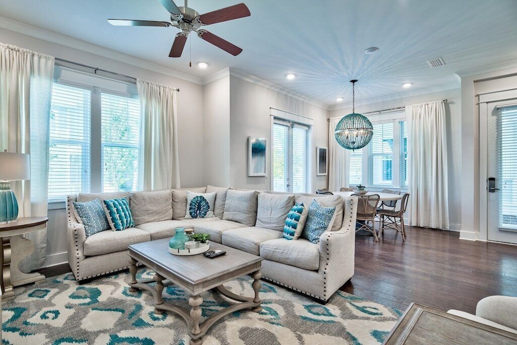 A spacious living room with a sectional sofa, a coffee table, and a chandelier.