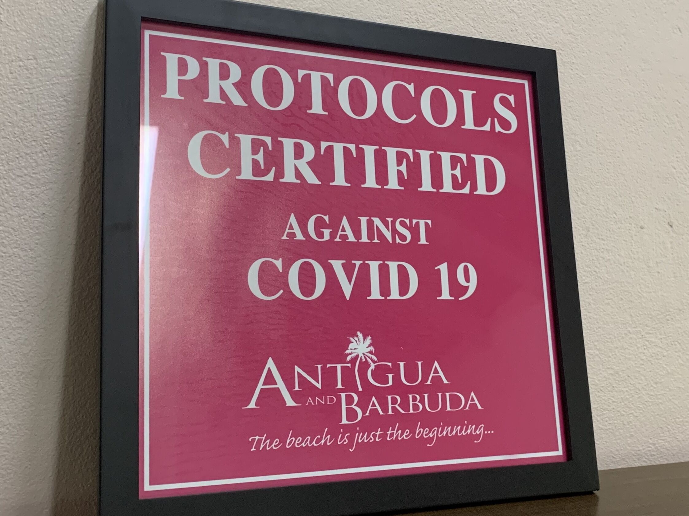 A framed sign with text about COVID-19 protocols.