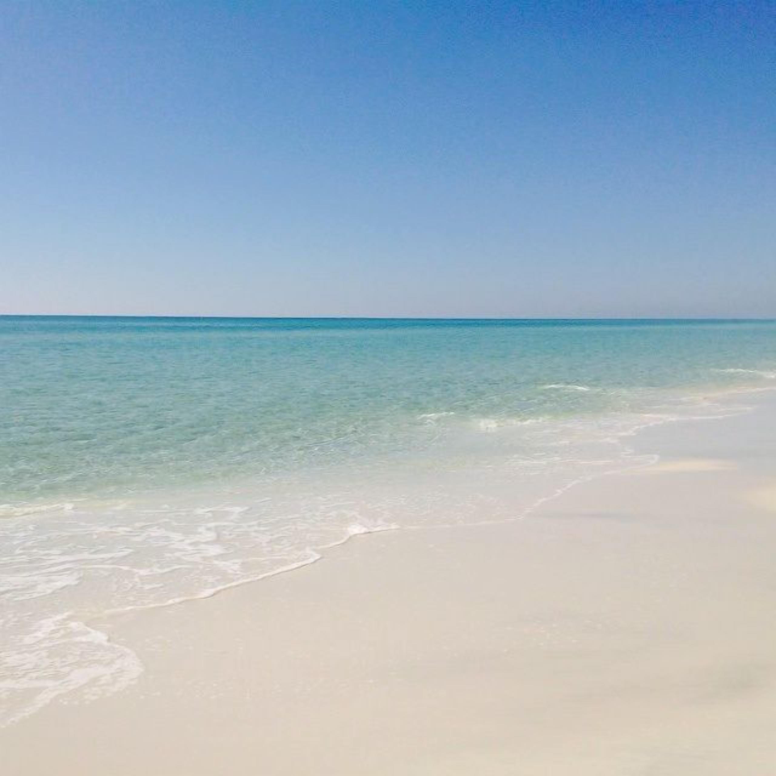 Una playa con agua turquesa cristalina y arena blanca.