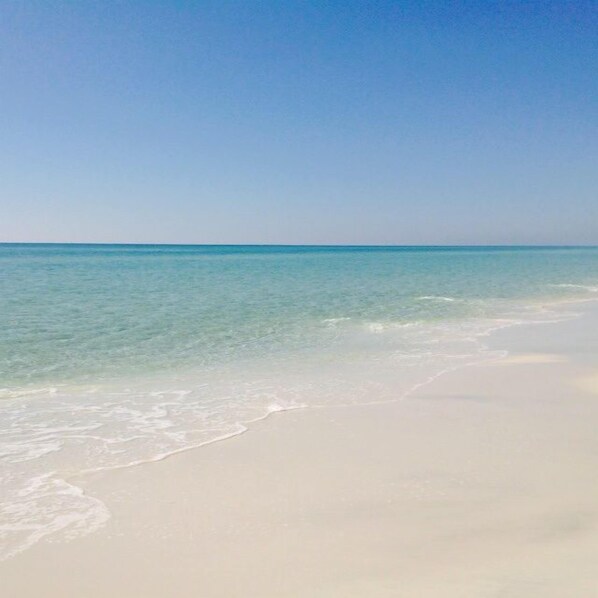 A beach with clear turquoise water and white sand.