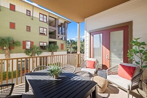A balcony with outdoor furniture, a table, and a potted plant. - 2 BR/2.5 BA condo/Redfish Village/Pool/Walk to beach/Beach chairs/umbrella (Santa Rosa Beach)