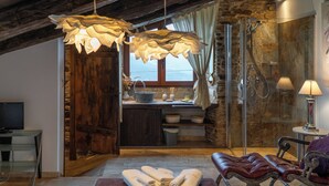 A modern bedroom with a large bed, a glass shower, and a view of the outdoors. - Complejo Rural Lar de Vies (A Pontenova)