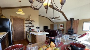 Un'ampia sala da pranzo con isola centrale, una cucina sullo sfondo e un camino.
