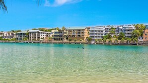 A coastal hotel with multiple balconies, a clear view of the sea, and a sandy beach. - Creekfront Kingscliff Waters 2 (KINGSCLIFF)