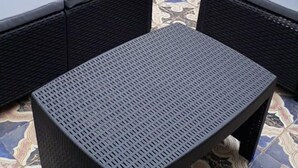 A small outdoor seating area with two wicker chairs and a square table, surrounded by patterned tiles. - B&B Dietro al Massimo (Palermo)