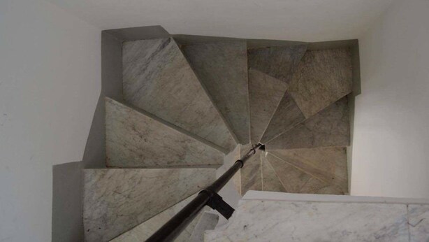 A spiral staircase with a modern design, made of stone or concrete, leading upwards. - B&B Dietro al Massimo (Palermo)