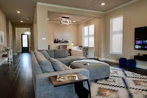 A modern living room with a sectional sofa, a coffee table, and a patterned rug.