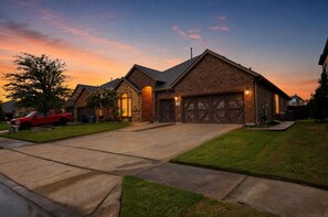 A residential house with a brick exterior, a stone facade, and a garage with large wooden doors.