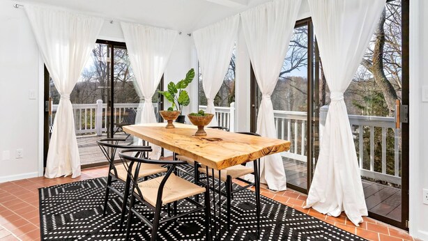 Un coin repas avec une table en bois, des chaises et une plante en pot.