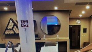 A hotel lobby with a pool area, a reception desk, and a large circular mirror on the wall. - PARADISE VILLAGE RESORT 2 BEDROOM ONE WEEK MAX (Nuevo Vallarta)