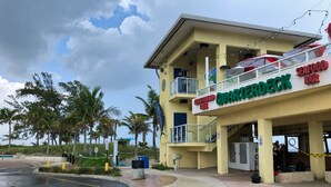 A multi-story building with a sign for 'Quarterdeck Seafood Bar' and 'Neighborhood Grill'. - Studio Suite - Minutes from everything (Dania Beach)