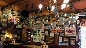 A diner with vintage decor, including license plates and neon signs. Tables are arranged for seating, and the interior features wooden furniture and a variety of hanging lights. - Studio Suite - Minutes from everything (Dania Beach)