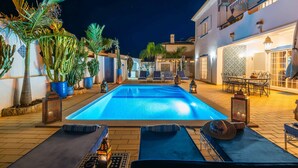 A swimming pool with lounge chairs and tables, surrounded by potted plants and architectural details. - Villa Oasis Galé - Luxury, private pool, AC, wifi and 5 mins from the beach (Albufeira, Faro)