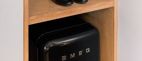 A wooden wardrobe with a coat and shoes.