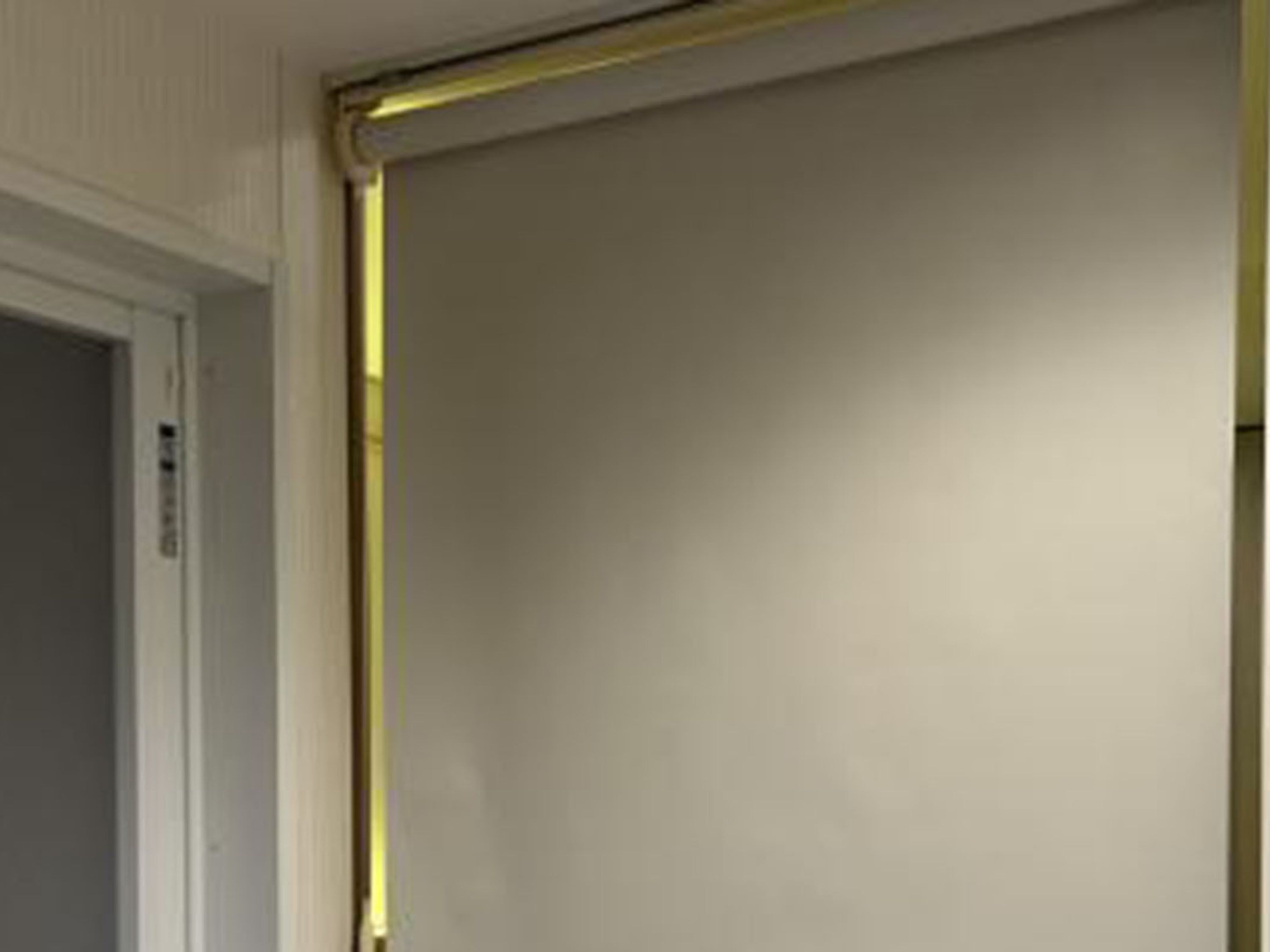 Une porte fermée, avec un cadre blanc et une bordure jaune.